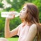 Woman sitting tired and drinking water after exercise.