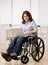 Woman sitting in wheel chair typing on laptop