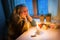 Woman sitting by the window with candles