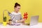 Woman sitting at workplace, showing big red hashtag symbol to laptop screen, sharing viral content.