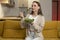 Woman is sitting on a yellow sofa enjoying a nutritious salad for lunch.