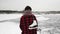 Woman with skates is on frozen ice lake. Young female with white figure skates standing on frozen pond. Winter outdoor activities