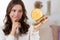 Woman with skeptical face expression watching a golden Euro coin