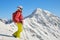 Woman skier with backpack and ski poles looks into the distance near Parpaner Rothorn peak. Breathtaking views in Arosa