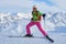 Woman skier with colorful clothes smiles and poses up in the Swiss Alps mountains. Arosa Lenzerheide resort, Switzerland