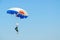 Woman - skydiver performs descent against cloudless blue sky