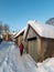 Woman with sled walking along the street. Kuldiga old town with historical houses in snowy winter day, Latvia