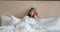 Woman with sleep mask and pajama lies on comfortable bed