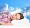 Woman sleeping on mattress. Blue sky on background