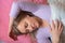 Woman sleeps on the back. Close-up portrait of 40 years woman with calm and relax face sleeping on pink pillow