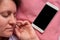Woman sleeps with mobile phone in a bed. Middle aged 40 years woman lying on pillow and smartphone is near her with black screen.