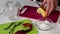 Woman slices a lemon on a cutting board. Near rosemary, salt and hot pepper. Ingredients for salting lemon