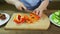 A woman slices vegetables peppers, cucumbers and black tomatoes and collects the finished dish salad. Time Laps