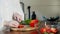 Woman slicing bell pepper at chopping board on kitchen counter indoors