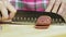 Woman slicing sausage on a wooden cutting board