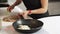 Woman slowly dices onion on wooden chopping board in kitchen