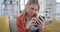 Woman, smartphone and scroll on sofa in home, reading social media notification and app. Happy gen z girl typing on