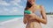 Woman with smartphone standing on beautiful exotic beach