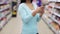 Woman with smartphone at supermarket or store