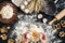 Woman smashes an egg using knife while kneading a pastry. Studio shot. Top view