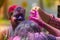 A woman smeared with colored powder, takes part in celebrations of the Dol Utsav Festival, a festival of the Hindu community, at