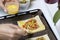 A woman smears a pizza with a battered egg. Chopped sweet peppers and olives on pizza puff pastry. The ingredients are placed on t