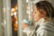 Woman smelling coffee beside a window in the night