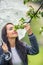 Woman smells tree flowers on during a spring rainy day in the nature, holding an umbrella