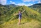 Woman with smile on the top of hill. Tourist travels through the mountains. Summer holidays in beautiful places