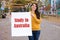 A woman smiles and holds a poster with the text Study in Australia