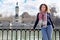 Woman smiles and leans on railing at background of monument