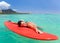 woman smiles on surfboard