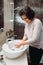 Woman smiling and carefully washing hands with soap and sanitiser in bathroom, details of hygiene, disinfecting hands