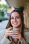 Woman smiling and drinking coffee in a cafe.