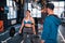 Woman smiling after lifting barbell standing near trainer