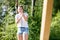 Woman Smiling While Pulling Rope Attached To Wooden Structure