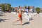 Woman smiling and running on beach near lounges