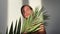 Woman with smooth skin holding tropical leaf and posing against t shadows