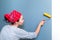 Woman smoothes air and glue bubbles on the wallpaper with a roller. An experienced master applies various techniques to