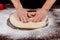 Woman smoothes yeast dough with her hands