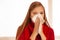 Woman sneezes holding a handkerchief nasal