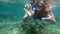 Woman in snorkel diving and waving with hands