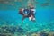 Woman in snorkel mask show thumb up underwater. Snorkeling in tropical sea coral reef. Girl in full-face snorkeling mask