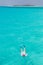 Woman snorkeling in clear shallow sea of tropical lagoon with turquoise blue water.