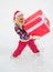 Woman in snow. Portrait of Santa woman with huge red gift looking at camera. Christmas Woman holding a huge gift box