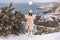 Woman snow sea. Amidst a wintry backdrop, a woman in a beige faux fur coat gleefully engages in a snowball fight, adding