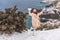 Woman snow sea. Amidst a wintry backdrop, a woman in a beige faux fur coat gleefully engages in a snowball fight, adding