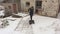 Woman with snow shovel clean the courtyard near the old barn