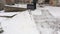 Woman with snow shovel clean the edge of the yard