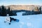 Woman with snowboard sits on fresh snow top of mountain